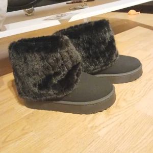 Svarta boots med pälsdetalj - Säljer ett par svarta boots i mycket bra skick. De har en mysig pälsdetalj runt som gör dem perfekta för kylan. Skorna är både snygga och bekväma. Perfekta för vintern!