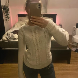 Vit stickad tröja från Sinsay - Säljer en superfin vit stickad tröja från Sinsay i storlek S. Den har ett snyggt flätmönster framtill och är perfekt för kyliga dagar. Tröjan är långärmad och har en bekväm passform. Perfekt för både vardag och mysiga hemmakvällar! 🤍
