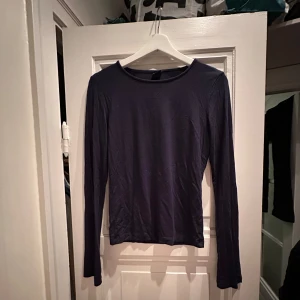 Mörkblå långärmad tröja - Säljer en stilren mörkblå långärmad tröja i mycket bra skick. Materialet känns mjukt och skönt mot huden. Enkelt att matcha!💙