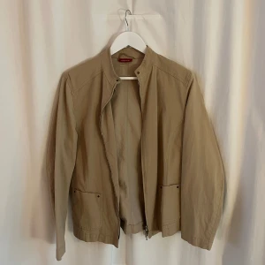 Beige jacka - Säljer en stilren beige jacka från Bianca. Perfekt för vår och höst. Jackan har en normal passform och är i mycket bra skick. Passar både till vardags och lite finare tillfällen.