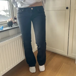 Svarta bootcut jeans - Säljer ett par svarta lågmidjade skit snygga jeans!! Märket är nudie jeans. Storleken är 27 w och 32 l. Lånade bilder då jeansen tyvärr inte passade mig. Pris kan diskuteras och skriv vid frågor!🥰🤩