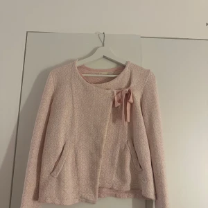 Rosa kofta från Odd Molly - Säljer en superfin rosa kofta från Odd Molly i storlek 1. Den har en söt rosett på framsidan och är i ett mjukt, stickat material. Jättefint skick!!💗🫶🏼