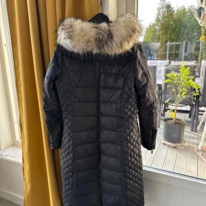 Svart quiltad vinterjacka med pälsdetalj - Säljer en snygg svart quiltad vinterjacka från Rockandblue. Den har en fluffig pälsdetalj runt huvan och dragkedjor på fickorna. Perfekt för kalla vinterdagar! 🖤