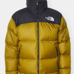 Säljer en supervarm och snygg dunjacka från The North Face i gult och svart. Perfekt för kalla vinterdagar! Jackan har en hög krage och dragkedja framtill. Den är i mycket bra skick och redo för nya äventyr. Passar perfekt för både stad och natur!