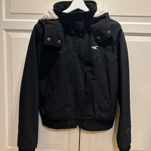 Hollister Jacka - Säljer en svart vinterjacka från Hollister i storlek M jag har dock XS och passar mig perfekt så skulle inte säga att den skulle passat för nån med M. Jackan har en mysig vit fleecefoder, den är perfekt för kalla dagar och har både dragkedja och knappar framtill. Hade en fakepäls på innan vilket jag inte tyckte om så tog av den och är nu borta.. Annars superbra skick och redo för vintern! Säljer den nu för 250 