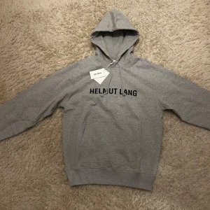 Helmut Lang hoodie - Tja säljer den här riktigt feta Helmut Lang hoodie. Den är i nyskick och är slut såld i princip överallt. Nypris 5000 kr, storlek M men passar även L. Hör av er ifall ni har frågor eller vill ha fler bilder.