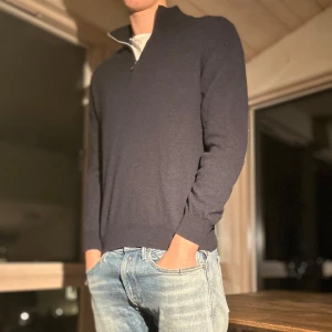 Mörk blå halv zip Oscar Jacobsson - Säljer en stilren mörkblå tröja från Oscar Jacobsson. Tröjan är i bra skick men har lite noppror.