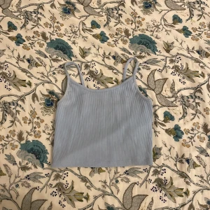 Ljusblå ribbad linnetopp från FB Sister - Säljer en söt ljusblå ribbad linnetopp från FB Sister i storlek XS. Perfekt för sommardagar eller som ett lager under en kofta. Toppen har smala axelband och en enkel design som gör den lätt att matcha med olika outfits. 🦋