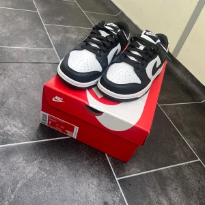 Nike Dunk Low  - Säljer ett par Nike Dunk Low panda i klassisk svart och vit färg. Skorna är i nytt skick och kommer med originalkartong. Perfekta för både vardag och fest med sin stilrena design och bekväma passform. Skorna har snörning och en slitstark sula.