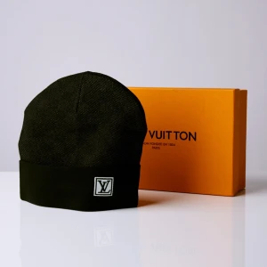 Svart mössa från Louis Vuitton - Snygg svart mössa från Louis Vuitton i ett stilrent och klassiskt utförande. Den har en broderad LV-logga framtill och är perfekt för att hålla dig varm med stil. Passar både till vardags och mer uppklädda tillfällen.