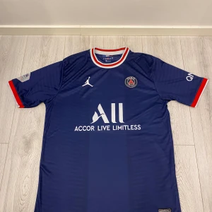 PSG Fotbollströja med Messi 30 - Säljer en PSG fotbollströja i bra skick. Den har korta ärmar med röda och vita detaljer. Baksidan har 'Messi' och nummer 30. Storlek XL men sitter mer som en L.