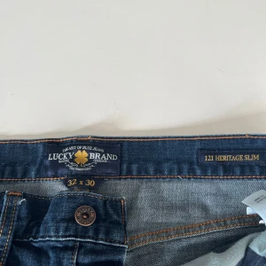 Blå jeans från Lucky Brand - Säljer ett par snygga blå jeans från Lucky Brand i modellen 121 Heritage Slim.
