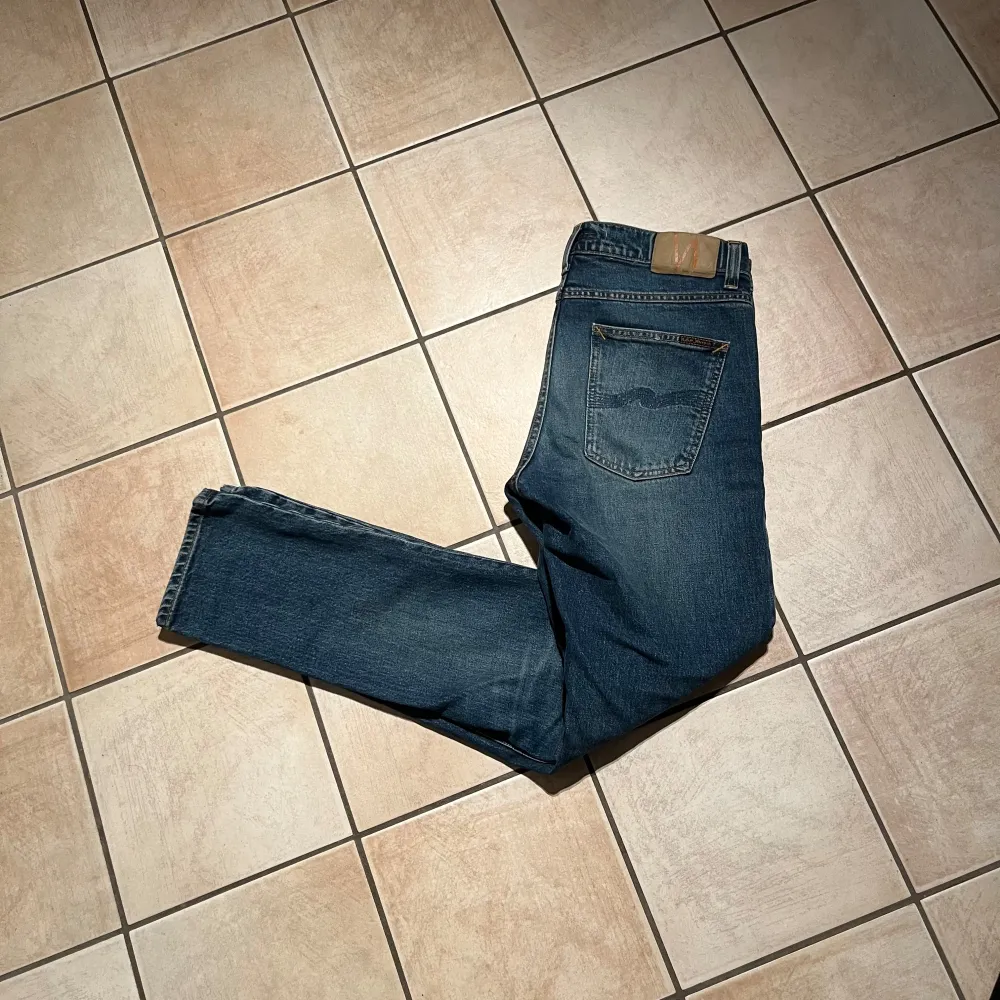 Säljer ett par snygga blå jeans från Nudie Jeans i bra skick. De har en klassisk femficksdesign och en bekväm passform. Helt nya, skick 10/10, storlek 30/32 hör av er vid funderingar!. Jeans & Byxor.