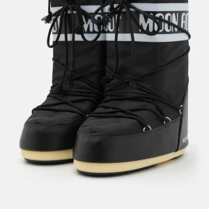 Svarta Moon Boots med snörning - Säljer ett par svarta Moon Boots i syntetmaterial med snörning i storlek 39-41. Perfekta för vintern med sin varma och bekväma design. De har en cool retrostil och är idealiska för snöiga äventyr. Sulan är i en kontrasterande beige färg som ger extra grepp. I nästintill nyskick