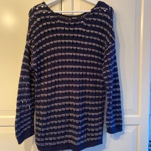 Mörkblå stickad kofta - Säljer en supermysig mörkblå stickad kofta. Den har ett snyggt vitt mönster och långa ärmar. Perfekt för höst och vinter när du vill hålla dig varm och stilren. Koftan har en öppen design baktill som ger en cool touch. Passar perfekt till både jeans och kjol!