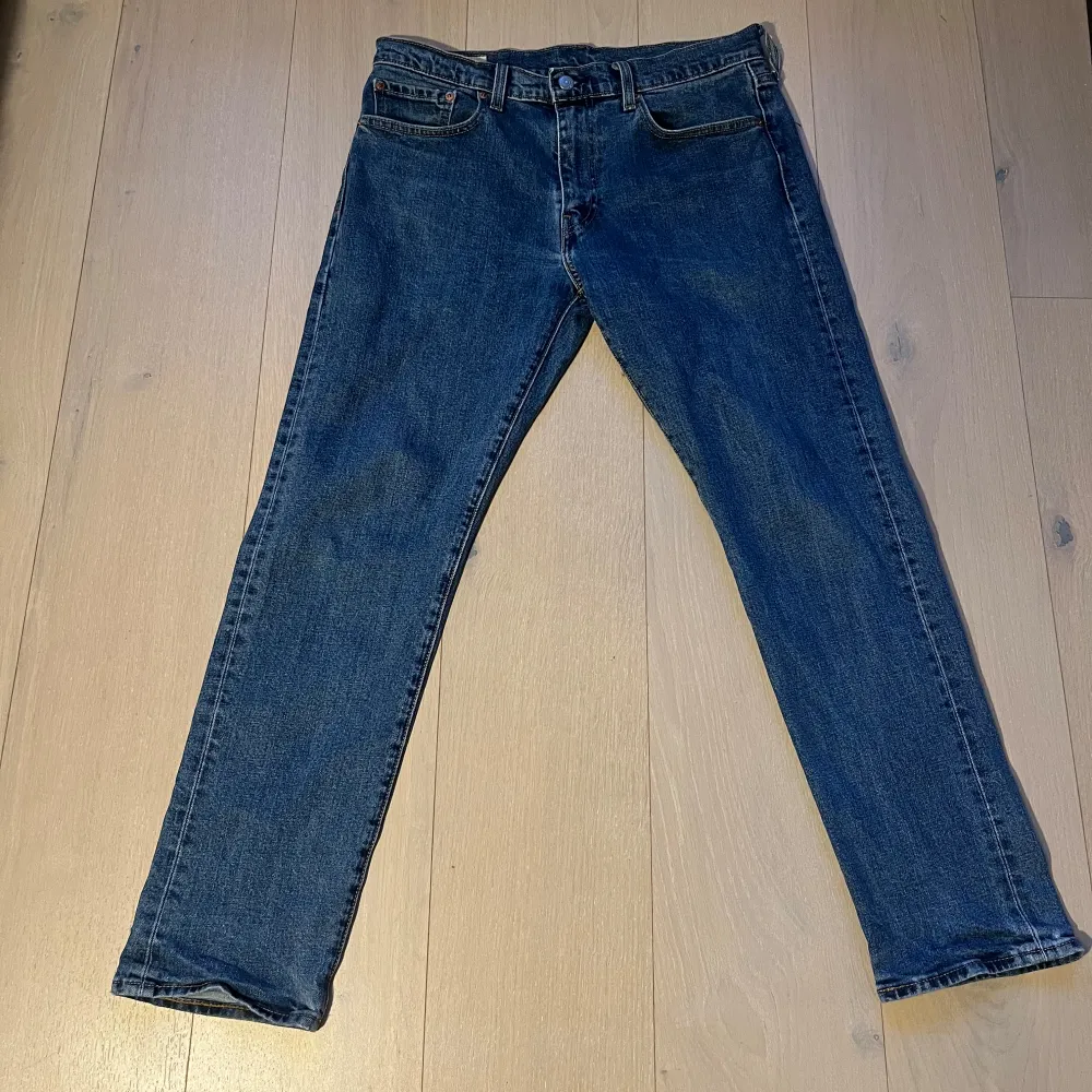 Säljer ett par klassiska Levi's Premium jeans i blå denim. De har en straight passform och är i mycket bra skick. Perfekta för vardagen. Storlek 32/30.. Jeans & Byxor.