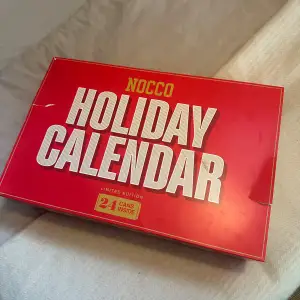 Säljer en limited edition NOCCO Holiday Calendar med 24 burkar inuti. Perfekt för att räkna ner till jul med en ny smak varje dag. Kalendern är röd med vit text och har en festlig design. Perfekt för NOCCO-fans som vill ha en energifylld december! Kalendern är helt oöppnad!💗