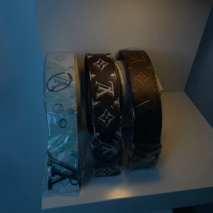 Tre bälten med monogrammönster - Säljer tre snygga bälten med monogrammönster. Ett i vitt, ett i brunt och ett i svart. Perfekta för att ge din outfit en lyxig touch. De är i nytt skick och kommer i plastförpackning. Passar både till vardag och fest! Dom säljs i styck 300kr 