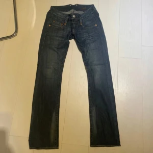 Lågmidjade jeans - Säljer ett par snygga mörkblå jeans i bra skick. Passformen är bootcut och low rise. Storlek 29/34, passar bra på mig som är 175 cm lång. Innerbenslängd: 85 cm midjemått rakt över: ca 40 cm