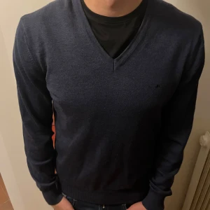 J.Lindeberg tröja  - Säljer en stilig mörkblå v ringad tröja från J.Lindeberg. Den är i storlek M och i bra skick. Hör av er vid frågor.