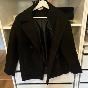 Svart kappa - Supersnygg kappa, lappen finns kvar och är helt oanvänd, är strl xs men sitter som s/m.🩷 den är varm och skön så man fryser ej i den