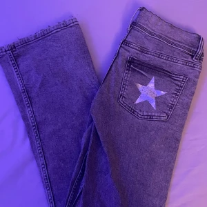 Gråa jeans - Säljer ett par grå low waist bootcut jeans i mycket bra skick. En stjärna på ena backfickan. Aldrig använda då det inte är min stil. Köpta på Gina men säljs inte längre. Nypris: 350kr
