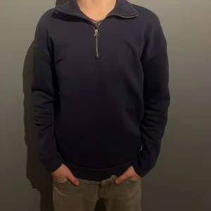 Mörkblå tröja med dragkedja från RYVLS - Säljer en stilren mörkblå tröja från RYVLS i storlek 146/152. Tröjan har en praktisk dragkedja vid halsen och långa ärmar. Perfekt för både vardag och lite kyligare dagar. Passar bra till jeans eller chinos för en avslappnad look. PRISET ÄR EJ SKRIVET I STEN!!!