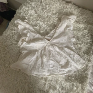 Vit blus från Nelly - Jättesöt vit topp från Nelly. Det är snören på ryggen som man knyter💕 den är i ett fint skick och är använd 2-3 gånger💕