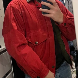 Röd jacka från Nautica - Säljer en snygg röd jacka från Nautica i bra skick. Den har en cool brun krage och knappar framtill. Perfekt för höst och vår med sin avslappnade passform. Jackan har praktiska fickor med knappar och är långärmad. Perfekt för dig som vill ha en stilren look!