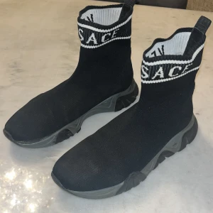 Svarta sock sneakers från Versace - Size 39 Versace Skor, Bra till Hösten/Sommaren. Den har en litet skada vid högra sidan sen små märken bakom skorna 