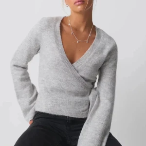 Grå omlottkofta - Säljer en supermysig grå omlottkofta från Gina Tricot med knytband i midjan. Perfekt för kyliga dagar, den är både stilren och bekväm. Koftan har långa ärmar och är gjord i ett mjukt material som känns skönt mot huden. Passar perfekt till alla tillfällen.  