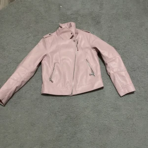 Rosa läderjacka - Storlek 134. Har knappt blivit slitna. 