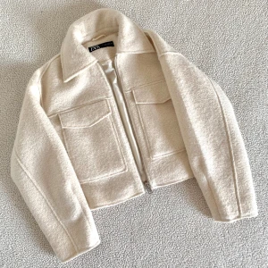 ZARA krämvit jacka med textur - Otroligt snygg krämvit jacka från ZARA med textur. Väldigt mysig och perfekt till hösten. ENDAST använd i några timmar. Utan anmärkningar, inga spår av användning. Stora fickor från båda sidorna.