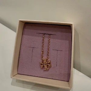 TORY BURCH • Halsband med logotyp i roséguld och kristaller - I princip helt oanvänd halsband från Tory Burch med logotyp. Funkar perfekt för dag och natt!  Färg: roséguld och kristaller