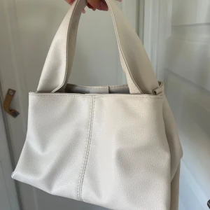 Vit trendig handväska - Säljer min vita handväska i imitations läder den har en trendig design och en ficka inuti🤍 
