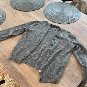 Söt polo Ralph lauren kofta  - En fin stickad kofta från polo Ralph lauren. Den har inga defekter förutom att den är lite nopprig men det är bara lite och inget man tänker på. Står att den är strl s men sitter som en xs. Tror den köptes för ca 1500❤️
