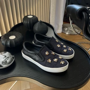 Christian Dior sneakers - Så snygga slip on från Christian Dior. Väldigt unika med deras original bee och säljs inte längre då det är en äldre kollektion. Har dessvärre inte kvar tillbehören, men självklart äkta! Skorna är i jätte bra skick! Ny pris ca 10 000kr.