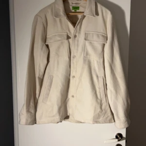 Beige overshirt från Feraud - Säljer en snygg beige overshirt från Feraud. Den har en klassisk design med knappar framtill och två stora bröstfickor. Perfekt för lager-på-lager under hösten eller våren. Materialet känns mjukt och bekvämt. Nypris 1.200. Mitt pris 299kr.