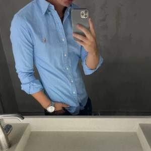 En ljusblå POLO RALPH LAUREN Slim Fit Shirt Oxford Blue  skjorta storlek M, nyskick och mjukt material