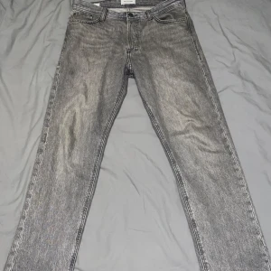 Jack & Jones jeans - Ett par gråa Jack & Jones jeans i storlek 30/32. Jeansen har en straight leg passform så dom ligger perfekt över skorna