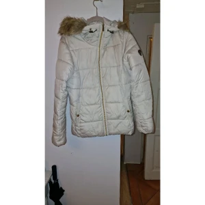 Off white vinterjacka  - Off white vinterjacka med guld-detaljer. Den är fin och håller dig varm under även de kallaste vinterdagarna. Näst intill oanvänd, i bra skick.