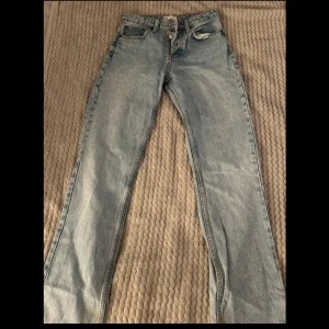 Blå jeansbyxor - Snygga blå straight leg jeansbyxor med klassisk design och knappgylf. Perfekta för en avslappnad stil.