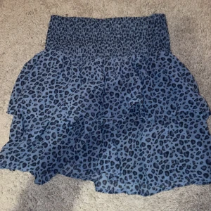 Blå leopardmönstrad kjol - Säljer en superfin blå kortkjol med leopardmönster. Kjolen har volanger. Den är i mycket bra skick!💙kjolen har ingen specifik storlek men skulle säga runt XXS - XS - S. Den är knappt använd! 