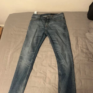 Blå jeansbyxor från tiger of sweden - Säljer ett par snygga blå jeansbyxor från tiger of sweden i den populära pistolero modellen. Storlek 29/32. De har en klassisk straight fit och är i mycket bra skick. Perfekta för både vardag och fest! 🕺‼️priset är inte hugget i sten‼️