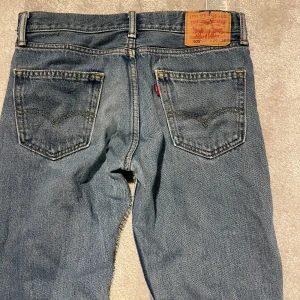 Levi's 505 jeans - Säljer ett par klassiska Levi's 505 jeans i blå denim. De har en rak passform och är midwaist. Perfekta för en avslappnad stil med sina ikoniska bakfickor och slitstarka material.