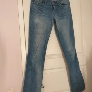 Lågmidjade bootcut levis jeans  - Säljer ett par klassiska blå Levis jeans med bootcut-stil. De är tillverkade av bomull med en liten del elastan för extra komfort. Perfekta för en avslappnad look.