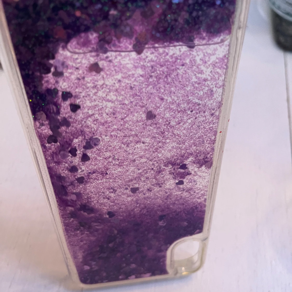 Genomskinligt mobilskal till IPhone xs  med lila glitter och vätska i. - 91