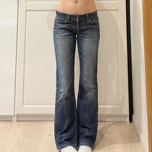 Lågmidjade bootcut jeans med hål🤩 - Midja 40 cm rakt över, gren 19 cm o innerben 77 cm💕jae 169 o xs-s o håller in lite i midjan och de är för korta! Märkta som W29/L32 vilket jag uppskattar till S. OBS lagningar i grenen 