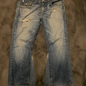  True Religion bootcut - Säljer ett par blå True Religion jeans. Custom bootcut. Använt ett par gånger då de är för stora.