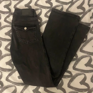 Svarta jeans i storlek XS - Säljer ett par svarta jeans från 157 i storlek XS. De har en klassisk femficksdesign med silverfärgade knappar och nitar. Jeansen är i bra skick och har en snygg, mörk tvätt. Perfekta för både vardag och fest!